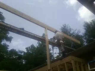 Carpenter setting a ridge beam over a new addition frame — Ice Dam Removal by Roofing Brothers in Biddeford Pool